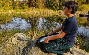 Boy in front of lake